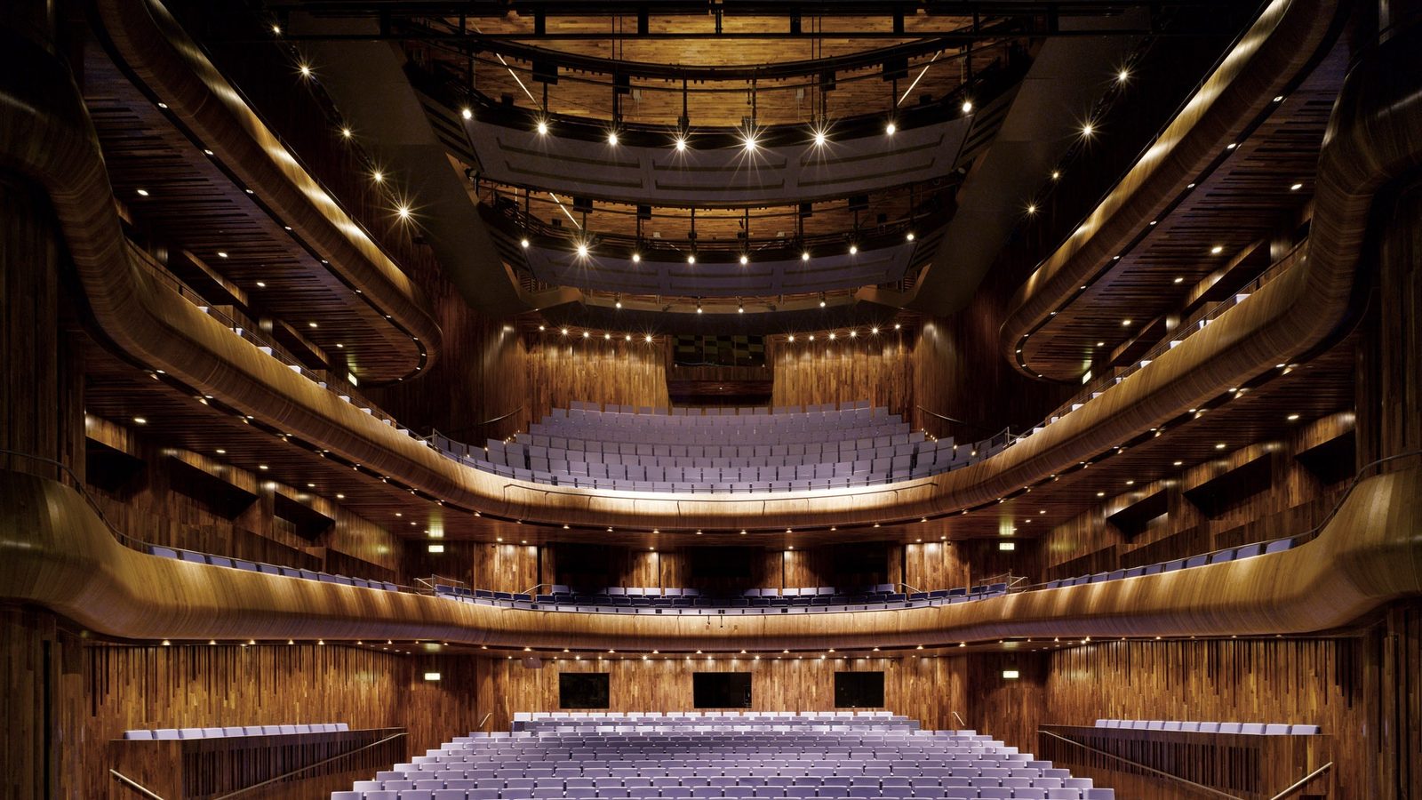 A concert hall balcony front, its underside shaped to return early sound to the seats below