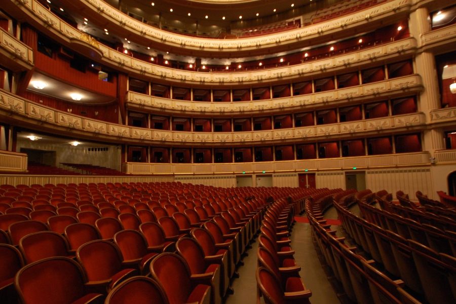 The horseshoe tiers of an opera house seen from the stage